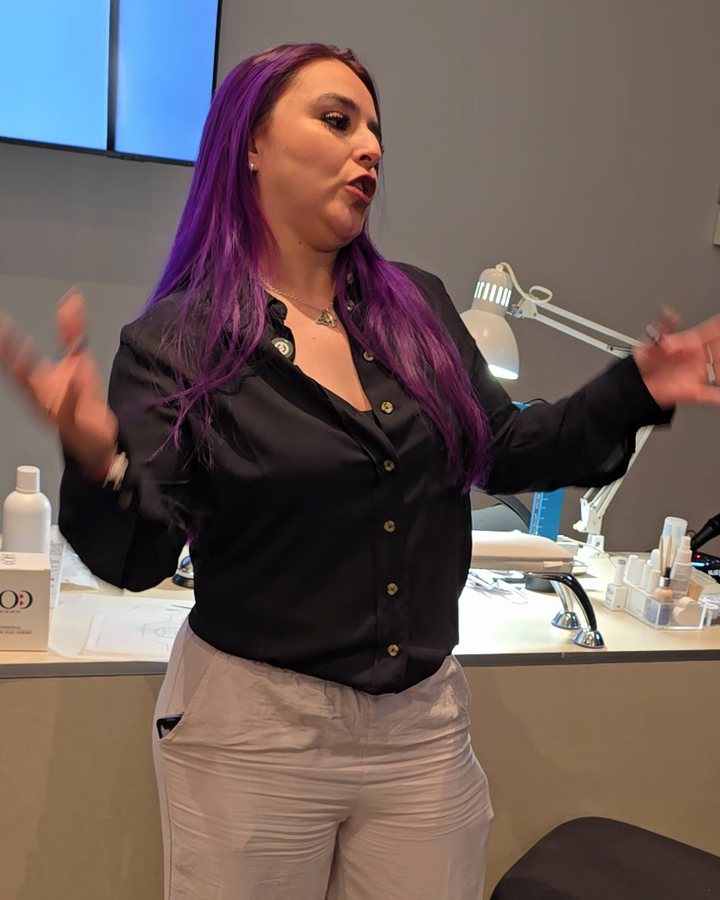 Alumna del Máster Formador de uñas explicando al grupo en su clase final como instructora